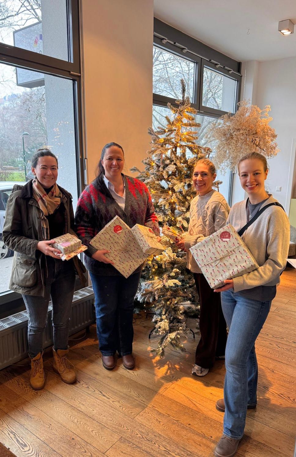 ein-packerl-team-mit-geschenken-am-christbaum